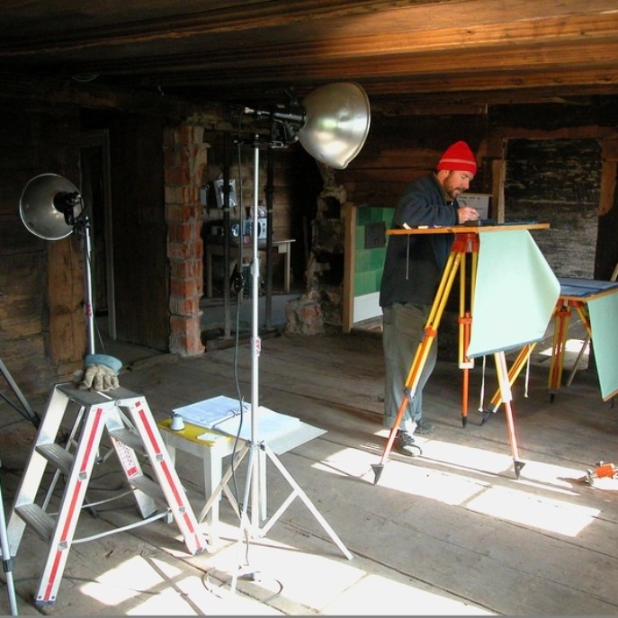 Ein Mitarbeiter beim Zeichnen eines Planes am Stehpult und in der Nähe der Lampe