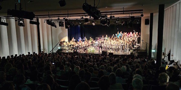 110 Sängerinnen und Sänger, Musikerinnen und Musiker geben zum Takt der Dirigentin ihr Bestes.