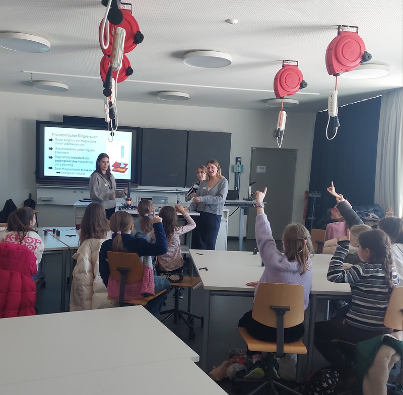 wissensdurstige Primarschülerinnen strecken ihre Finger in die Luft