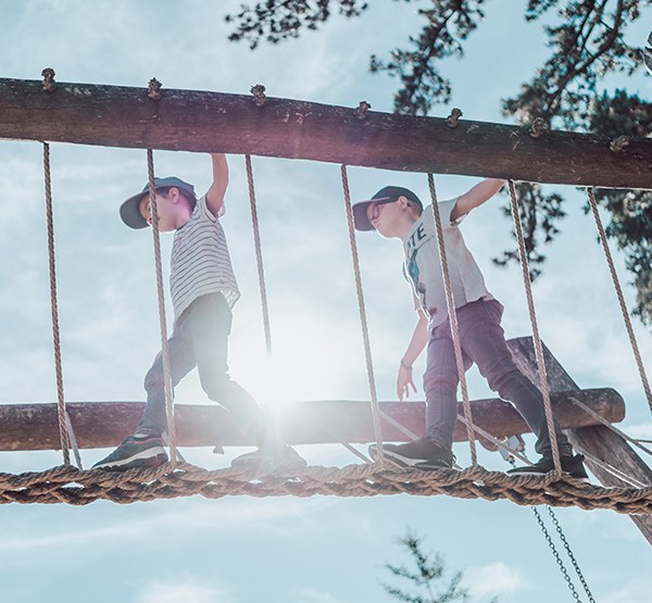 zwei Kinder gehen über eine Brücke