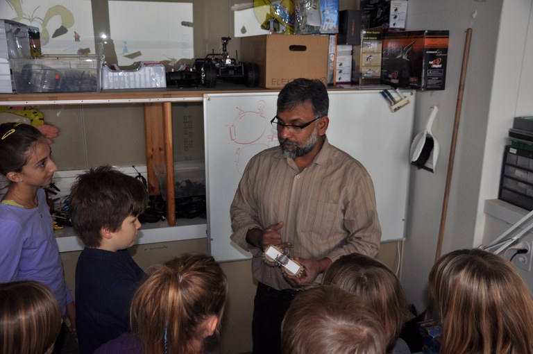 Tüftellabor - Leiter Jonny Padua zeigt den Kindern einen Bürstenroboter.