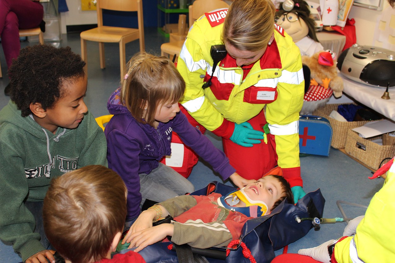 Kinder und Rettungssanitäterin Andrea Jutzi behandeln ihren "Patienten" 