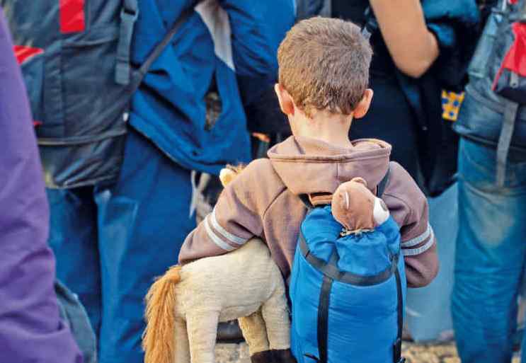 Kind mit Rucksack und Stofftier