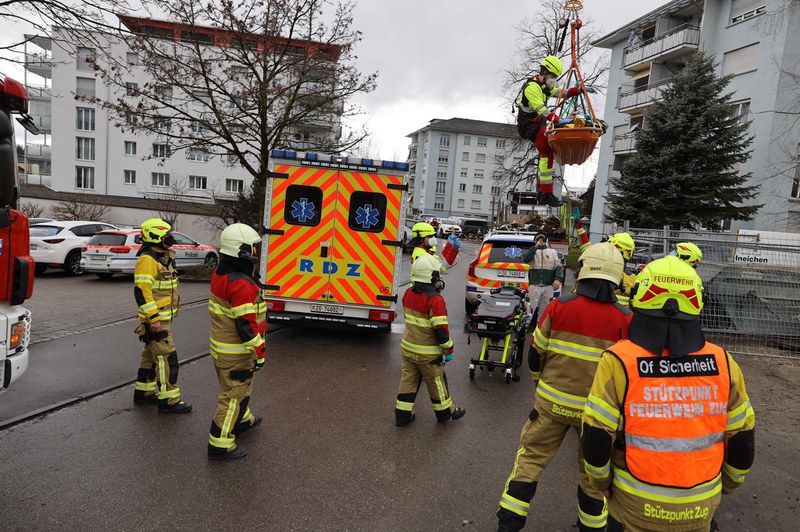 Verletzter Bauarbeiter wird mit dem Baukran zum Rettungswagen herabgelassen.